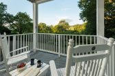 Private porch with Adirondack furniture that overlooks a garden