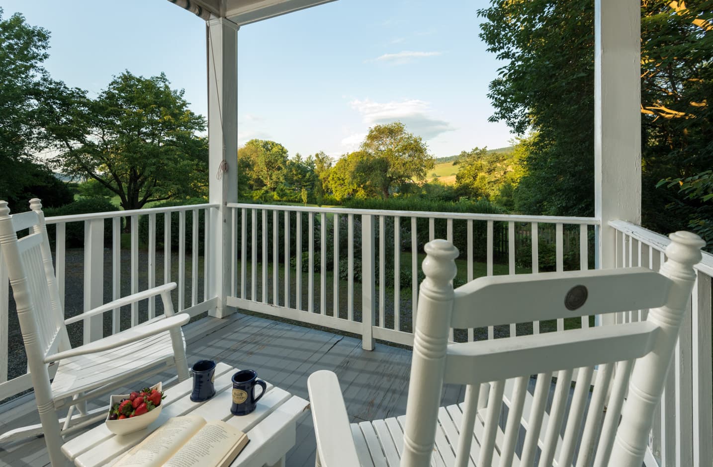 Private porch with Adirondack furniture that overlooks a garden