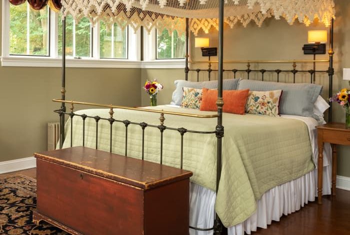 Wrought iron king bed with a trunk at the foot of the bed in a spacious room