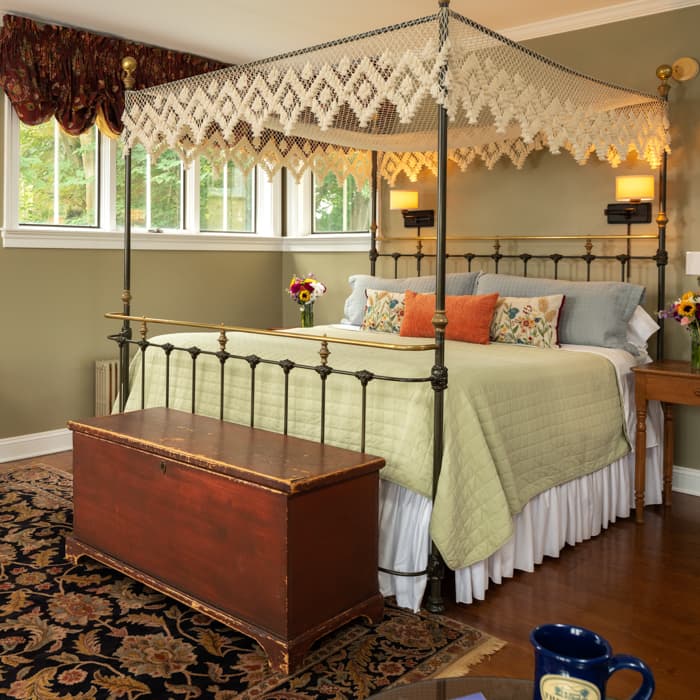 Wrought iron king bed with a trunk at the foot of the bed in a spacious room