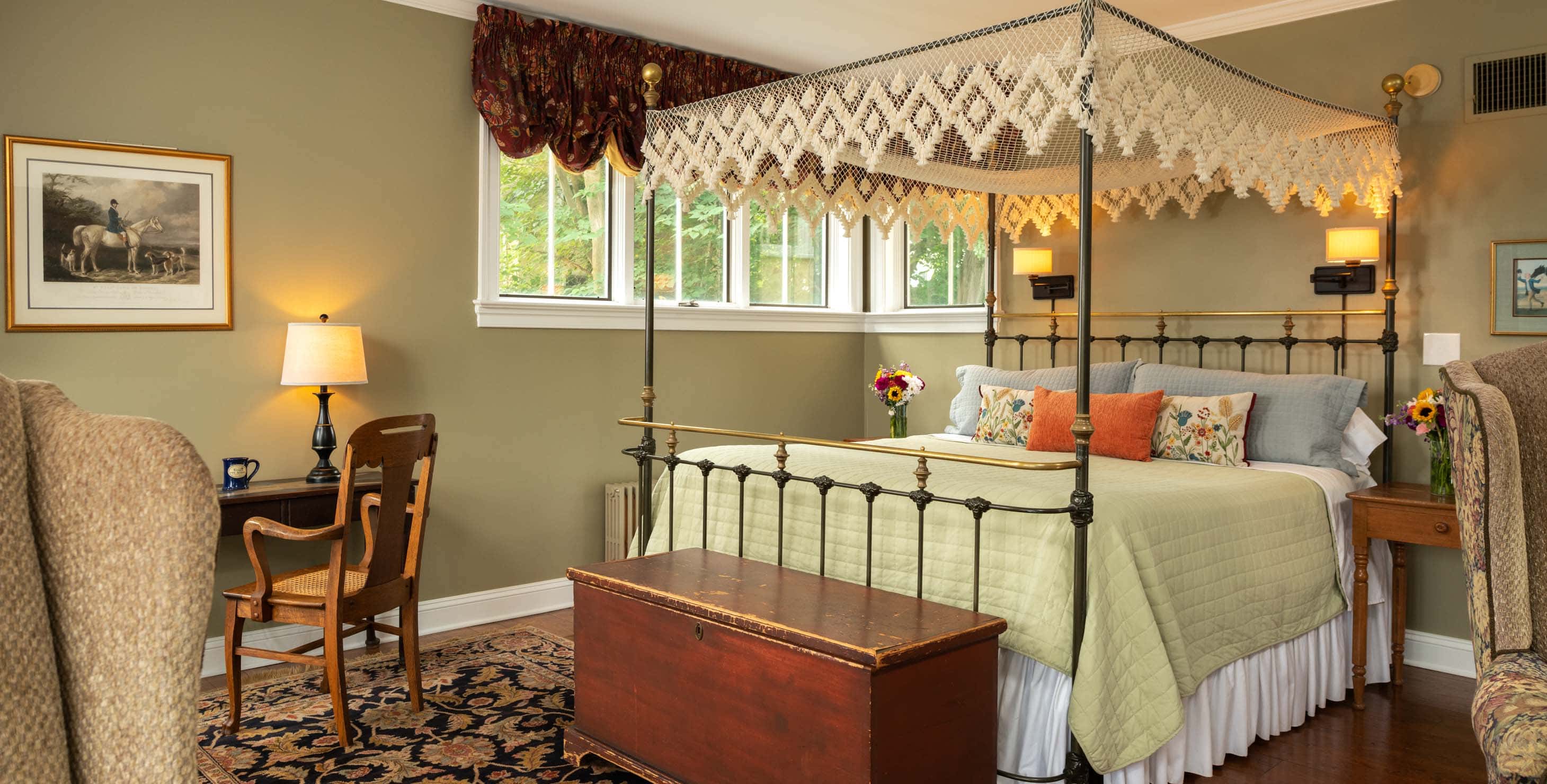 Wrought iron king bed with a trunk at the foot of the bed in a spacious room