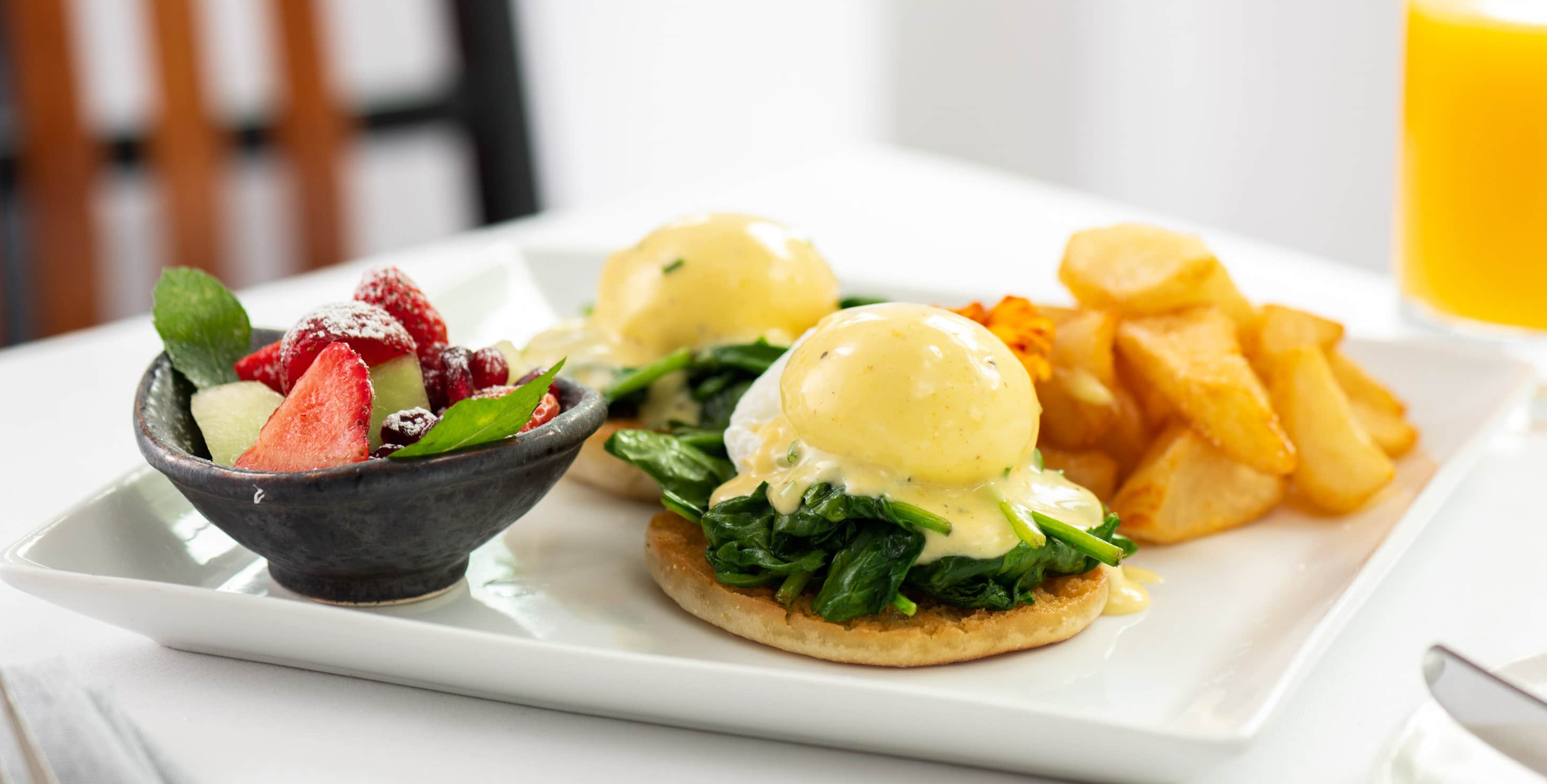 Eggs Benedict served with breakfast potatoes and sides