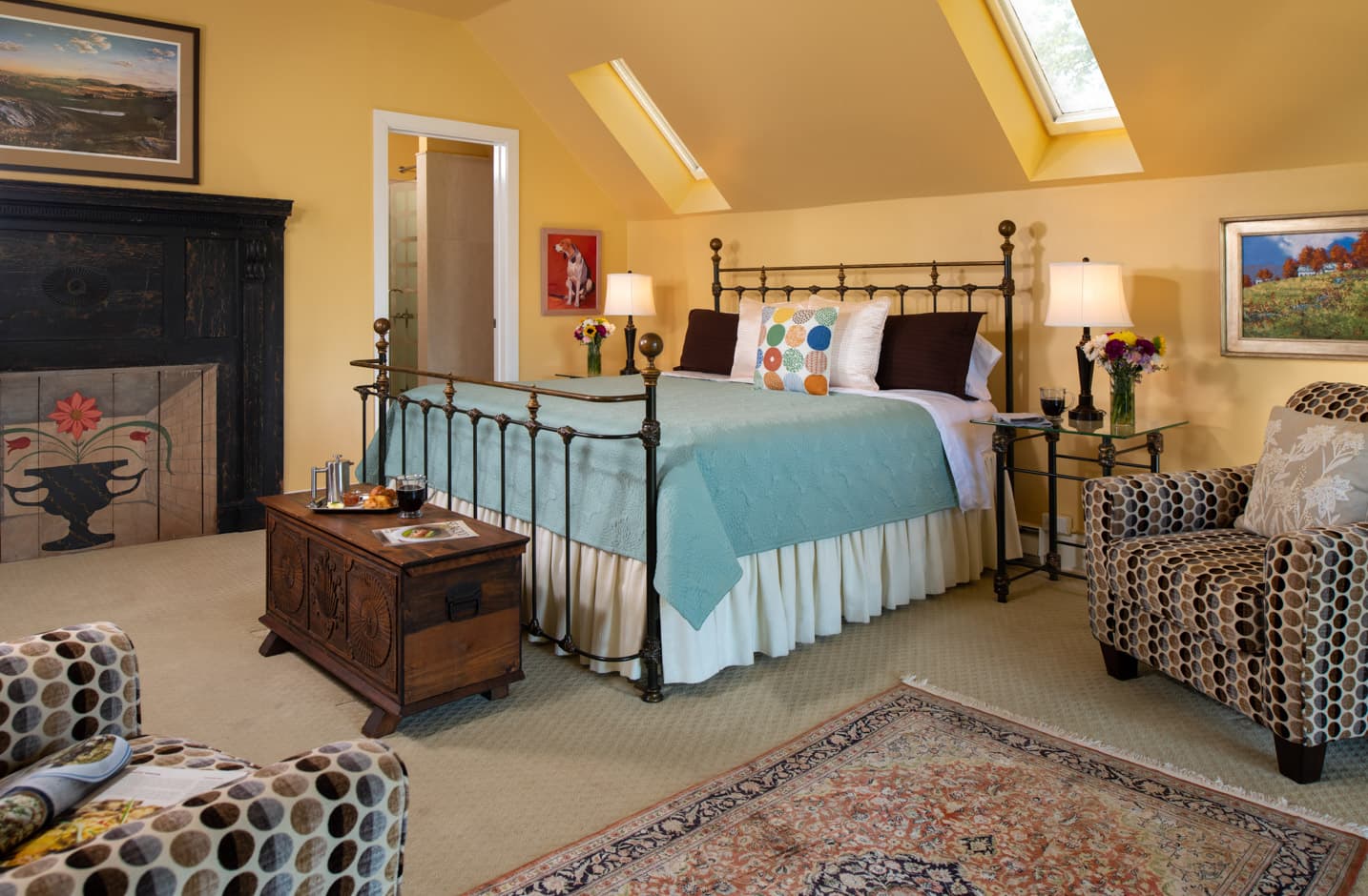 King Bed in a spacious room with yellow walls and a seating area at The Ashby Inn