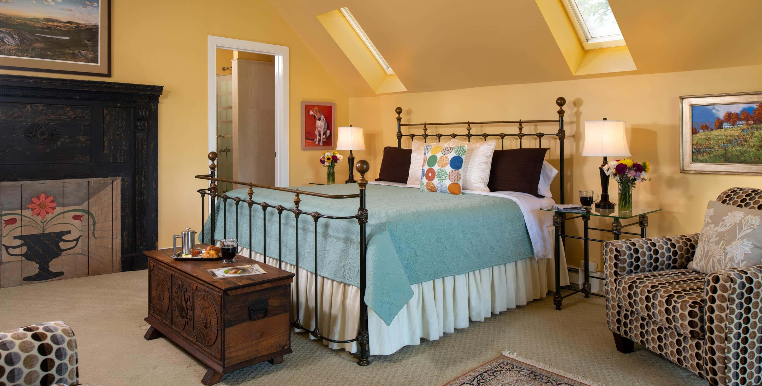 King Bed in a spacious room with yellow walls and a seating area at The Ashby Inn