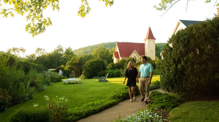 A couple walking down a path with the Ashby Chapel in the background