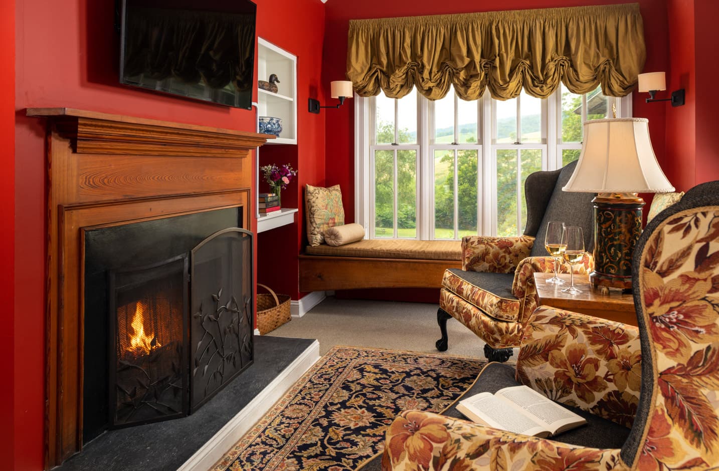 A seating area for two in front of a fireplace and flat screen TV