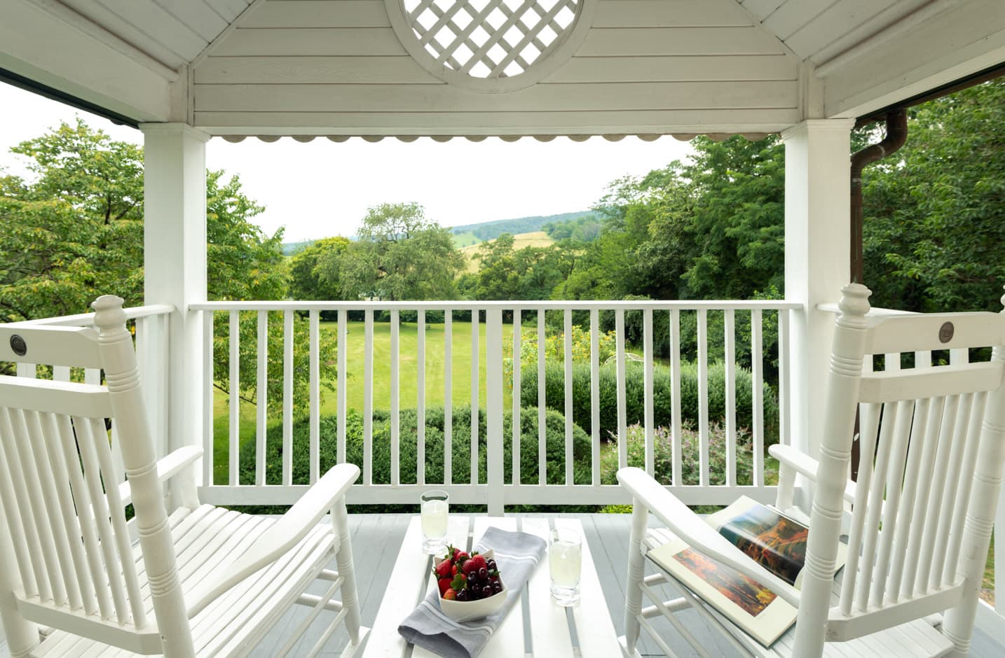 Private porch with Adirondack furniture that overlooks a garden and spectacular views of the Blue Ridge