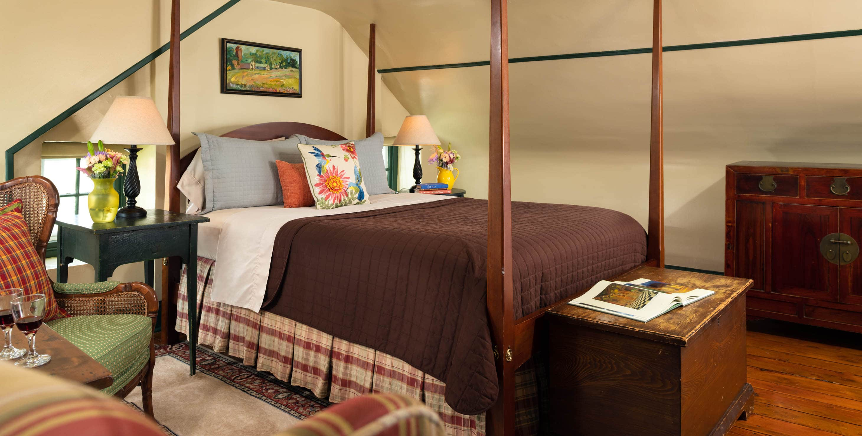 Queen size pencil-post bed in a room with country furnishing and a trunk at the foot of the bed