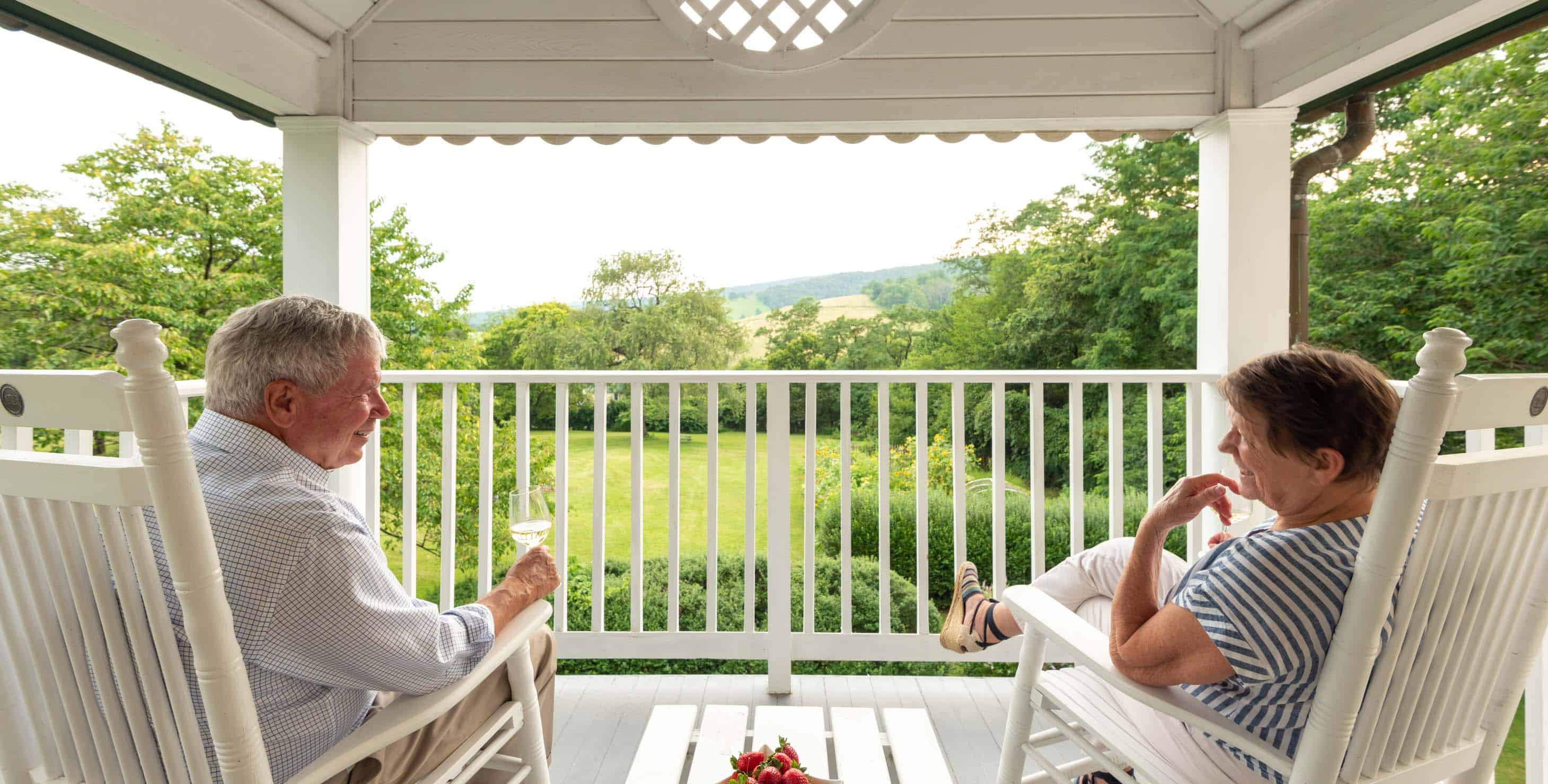 Two people sitting on chairs on a second floor balcony