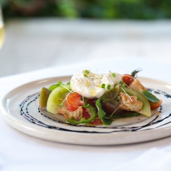 Seasonal vegetables with a poached egg served with a glass of white wine