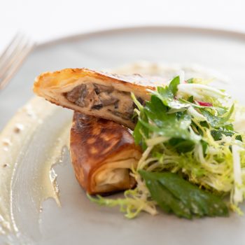 A entree served with salad on a gray plate