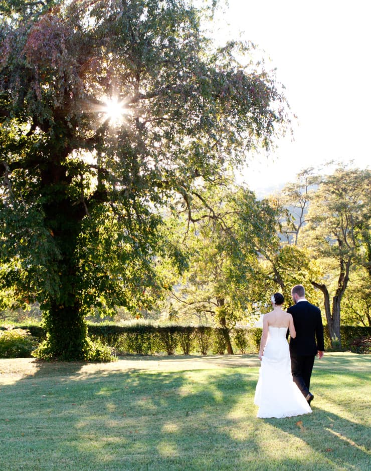 Bride and groom standing near a tree at Ashby Inn